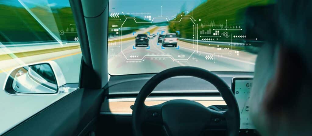 View from inside a car showing a screen with digital overlays and a driver in the foreground, suggesting advanced driving assistance or autonomous driving technology in use, seamlessly integrating parking lot management systems for an efficient experience.