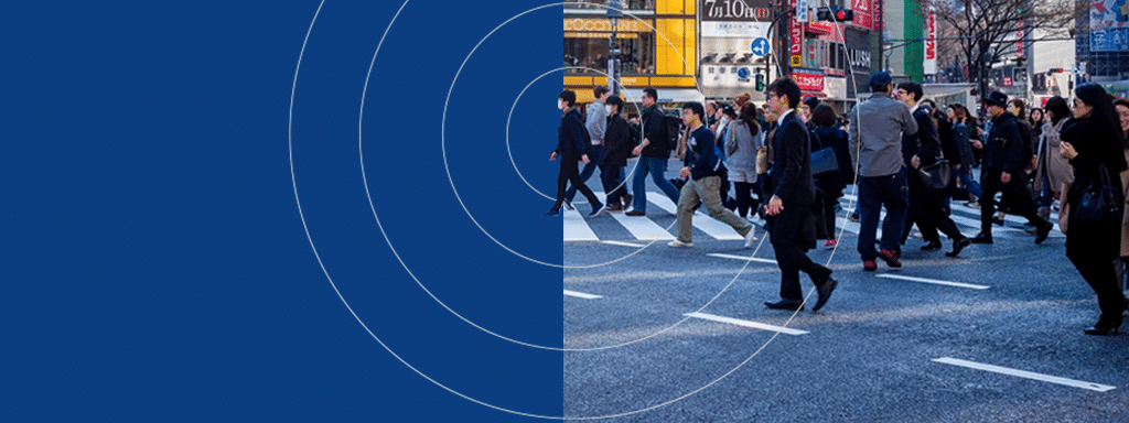 A crowd of people walking across a busy city street intersection, with a blue overlay featuring concentric circles on the left side of the image reflecting efficient parking management.