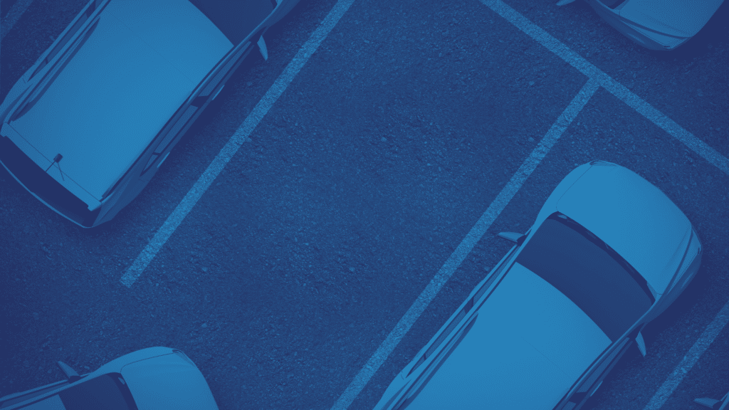 Aerial view of several cars parked in an outdoor parking lot with marked spaces, showcasing efficient parking lot management by WayleADR for seamless commercial parking.