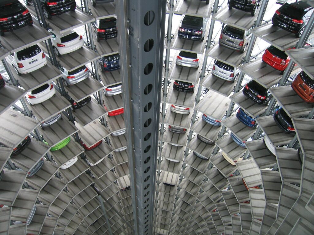 Vertical view of a multi-level automated car parking system with numerous vehicles neatly parked in individual slots on various levels.
