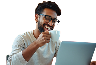Man with glasses smiling, holding a cup, and looking at a laptop.