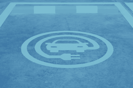 A parking spot with a painted symbol indicating it's designated for electric vehicle charging, ideal for commercial parking areas.